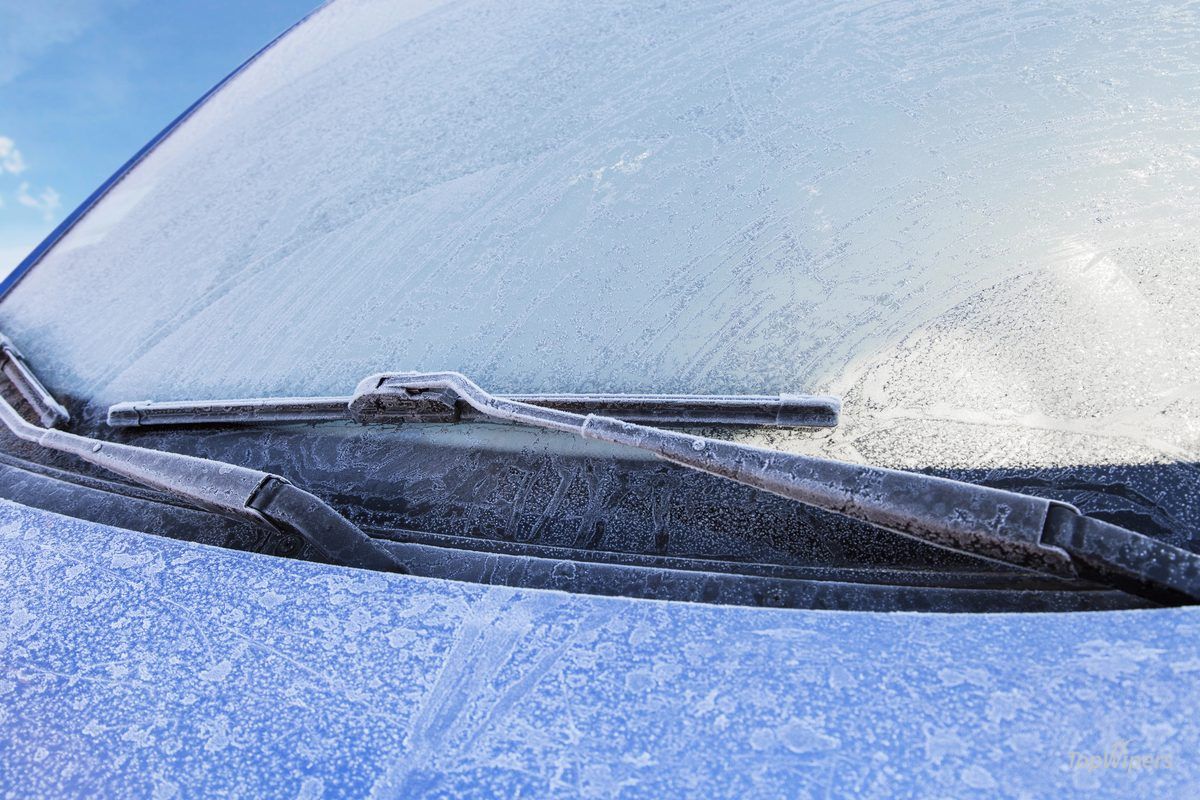 Scheibenwischer auf einer verschneiten Windschutzscheibe an einem frostigen Wintermorgen