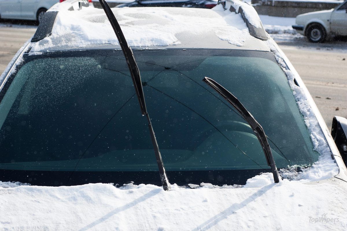 Wiper arm lifted off a frosty windscreen in the evening to prevent freezing