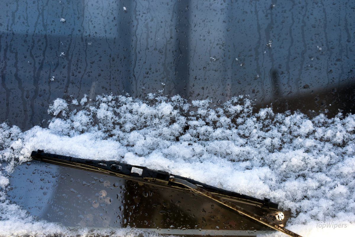 Balai d'essuie-glace couvert de neige et de glace sur le pare-brise